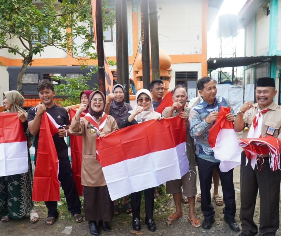 Bupati Pandeglang Raden Dewi Setiani membagikan bendera Merah Putih kepada warga di Jalan Carita–Anyer, Kecamatan Carita